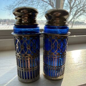 Vintage cobalt blue glass and silver-plated salt and pepper shakers.